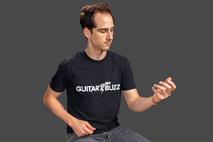 Image of AL holding arm up with no guitar]