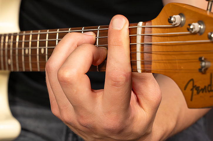 AL’s left hand playing a power chord